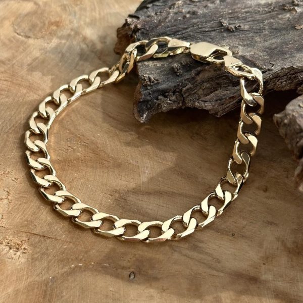 Panzerarmband für Herren aus 585 Gelbgold, 7mm breit und 22cm lang, auf Holz liegend. Die warme Goldfarbe kommt im natürlichen Licht besonders zur Geltung. Artikelnummer 16111-A