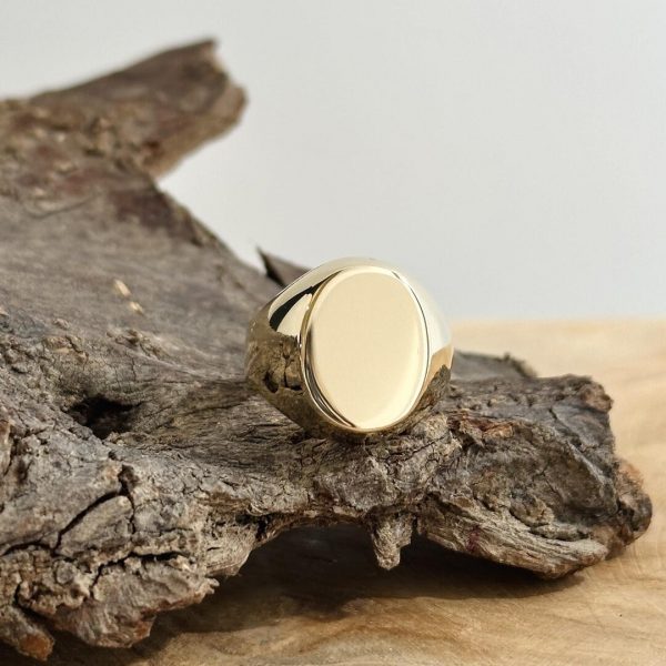 Massiver 585er Gelbgoldring für Herren, stilvoll auf einem Stück Holz präsentiert.