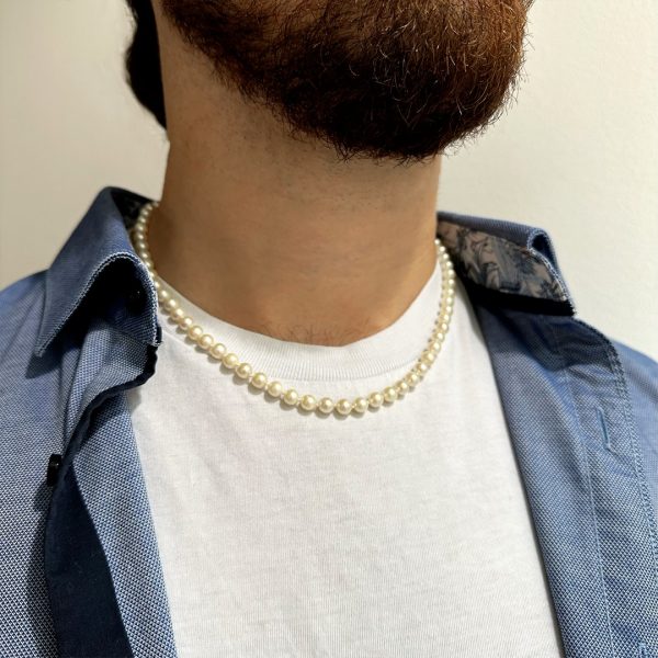 Lässige Herren-Perlenkette kombiniert mit einem blauen Hemd und weißem T-Shirt – ein moderner Look für stilbewusste Männer.