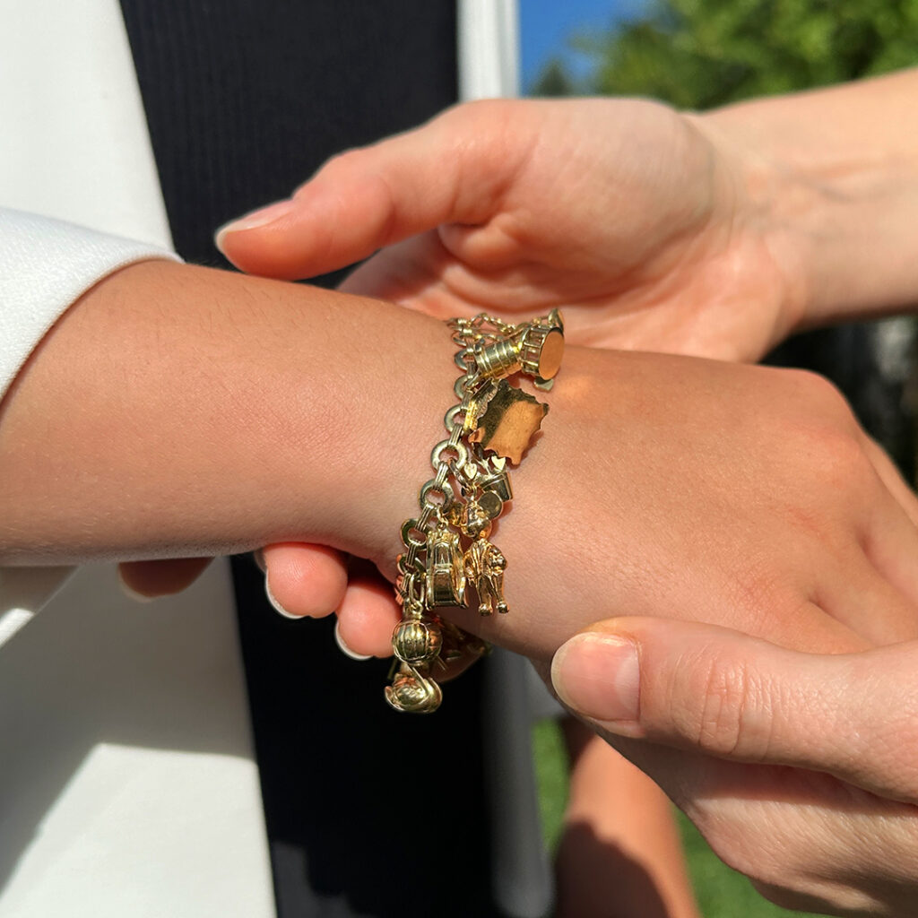 Kind trägt ein Bettelarmband und hält die Hand der Mutter