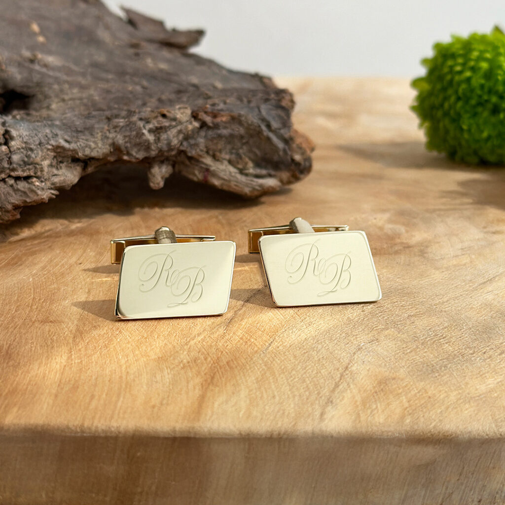 Manschettenknöpfe aus Gold für Herren auf Holzplatte