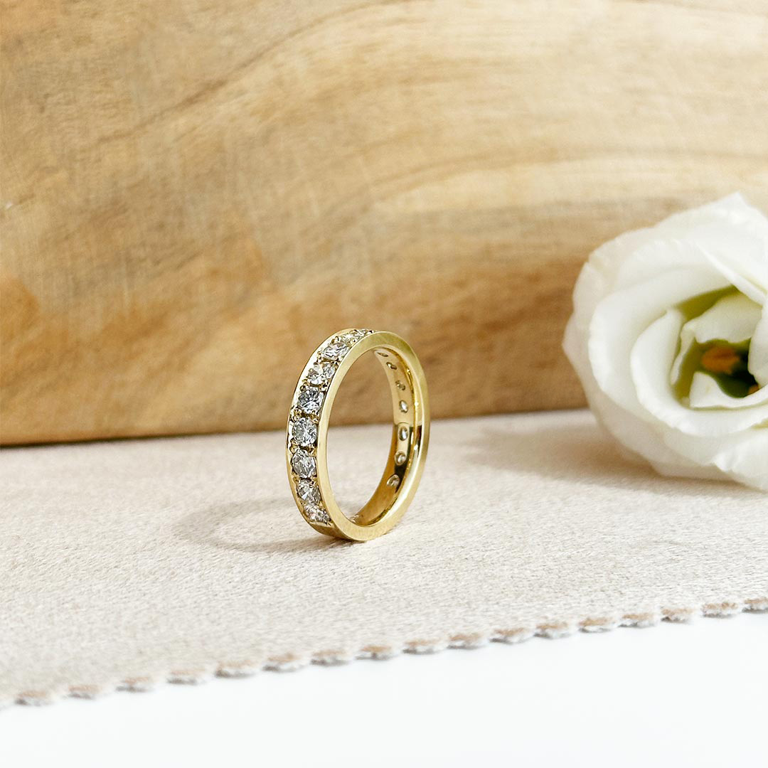 Schmuckanfertigung Memoire Ring aus 585 Gelbgold fotografiert auf elegantem Stoff.