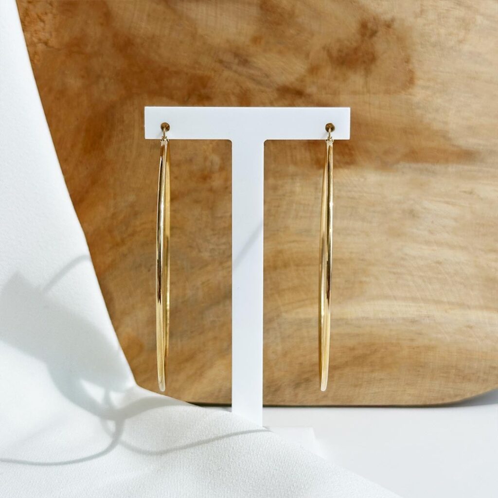 Runde Creolen aus 585er Gelbgold mit 62mm Durchmesser und 1,5mm Drahtstärke, frontal auf Schmuckaufsteller präsentiert, Fokus auf die klare Form, die feine Verarbeitung und die zeitlose Wirkung