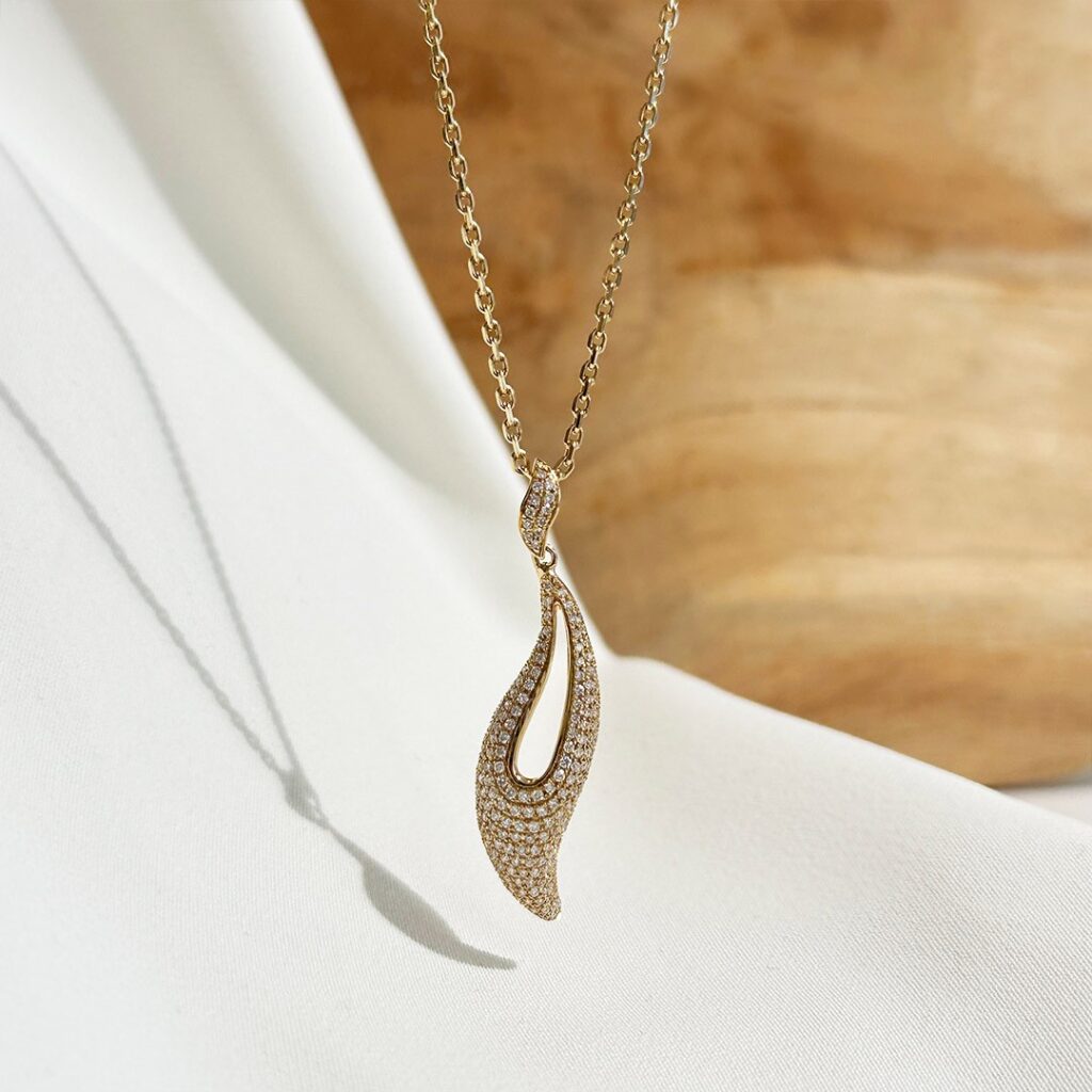 Diamantanhänger aus 585 Gelbgold mit geschwungenem Design und funkelnden Diamanten, an einer Goldkette elegant in Nahaufnahme dargestellt.