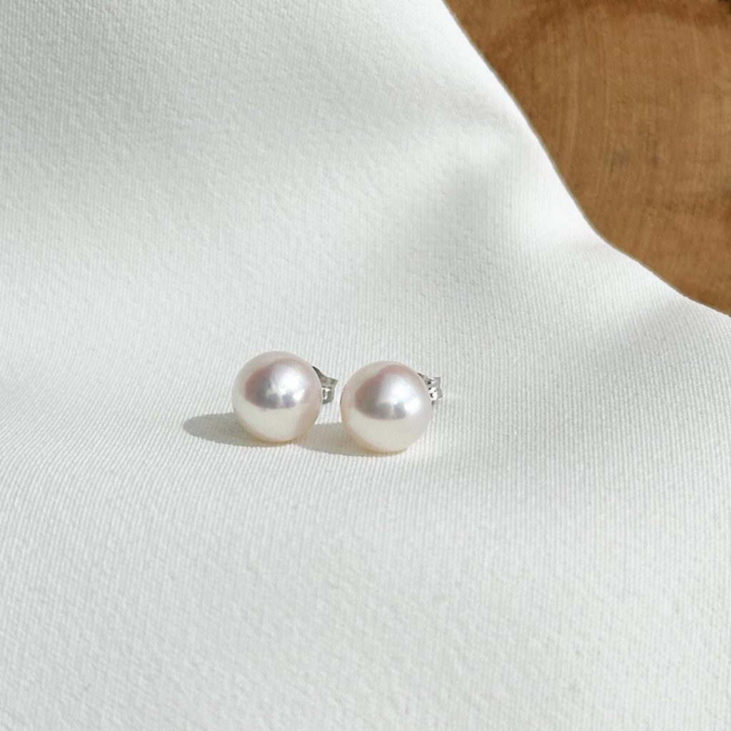 Akoya-Perlenohrstecker mit 7,5mm Perlen und 585 Weißgoldfassung in klassischer, frontaler Ansicht.