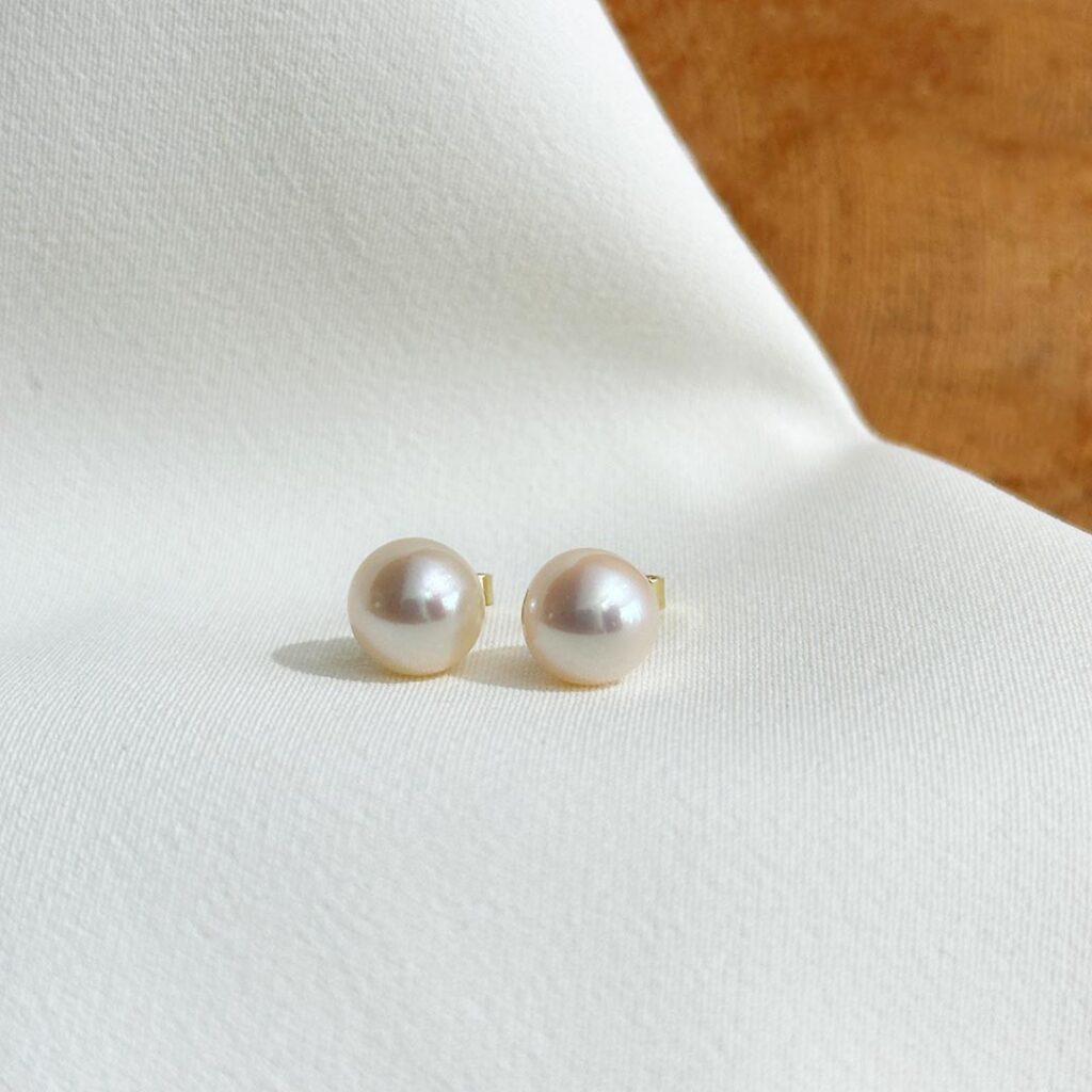 Akoya-Perlenohrstecker aus 585 Gelbgold mit 8mm Perlen und warmem Rosé-Lüster in frontaler Ansicht.