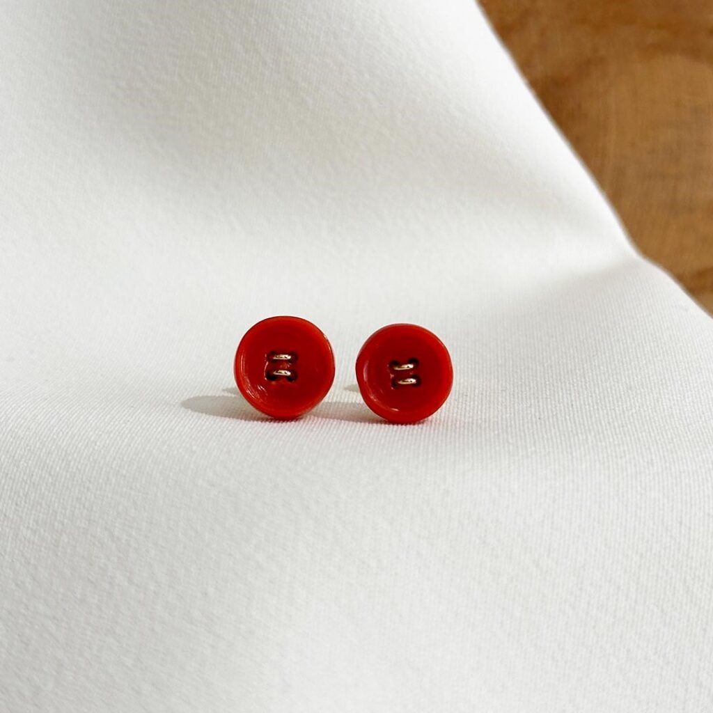 Runde Korallen-Ohrstecker mit feinen „Nähten“ aus 585er Gelbgold, ca. 9mm groß, in klarer Frontansicht elegant fotografiert.