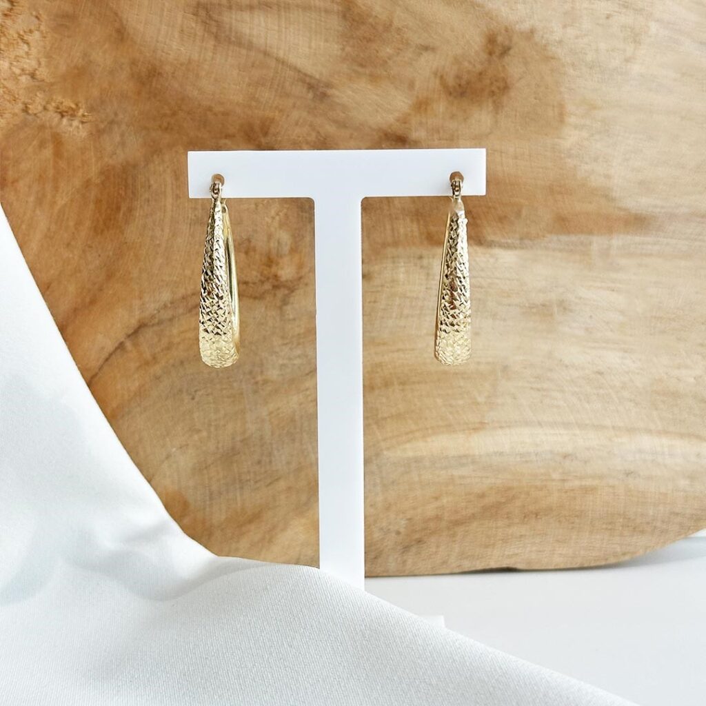 Ovale Creolen aus 585er Gelbgold mit sanft verbreiterter Form nach unten und strukturierter Oberfläche, als klare Produktaufnahme präsentiert.