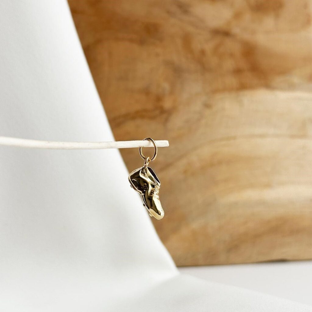 Rennradschuh-Anhänger aus 585 Gelbgold in eleganter Nahaufnahme, detailreich gearbeitet und als Bettelarmband-Schmuckstück präsentiert.