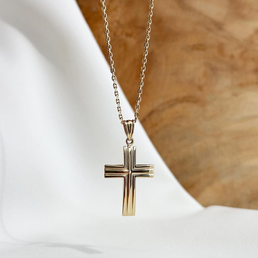 Kreuzanhänger aus 585 Gelbgold mit fein gearbeiteten Rillen und 30mm Länge, elegant in Nahaufnahme an einer Goldkette präsentiert.