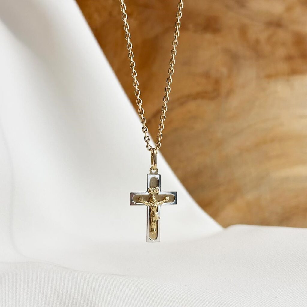 Kreuzanhänger mit Korpus aus 585 Gold in Bicolor-Optik, fein ausgearbeitet in Gelb- und Weißgold, klar und detailreich frontal präsentiert.