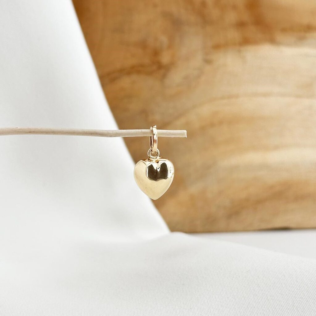 Herz-Anhänger aus 585 Gelbgold, 13mm groß, klassisch gestaltet und in eleganter Nahaufnahme vor einer Holzwand fotografiert.
