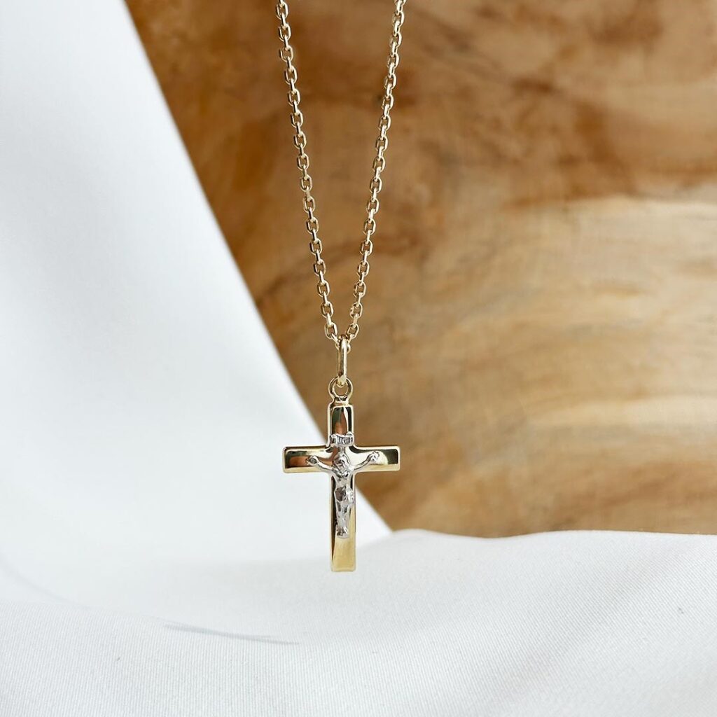 Kreuz-Anhänger mit Korpus aus 585 Gold bicolor, 25mm groß, mit fein herausgearbeitetem Relief und polierter Oberfläche, in eleganter Nahaufnahme präsentiert.