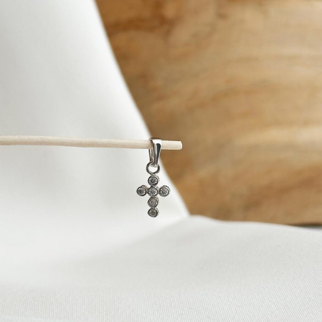 Zarter Mini-Kreuzanhänger aus 585 Weißgold, 10mm groß, mit rund gefassten Zirkonia-Steinen, filigran und elegant in Nahaufnahme gezeigt.