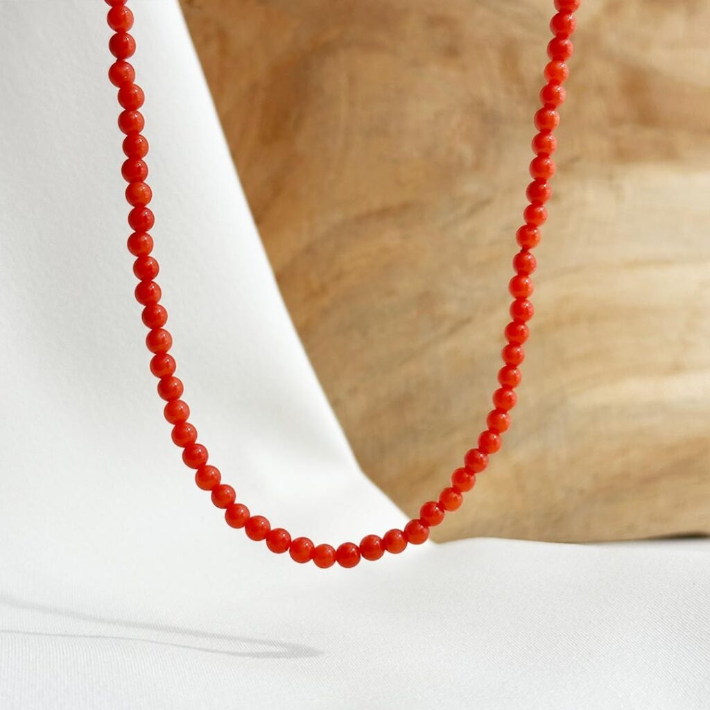 Zarte Korallenkette mit 3mm Korallenkugeln, 42cm Länge und Springringverschluss aus 585er Gelbgold, in eleganter Nahaufnahme dargestellt.