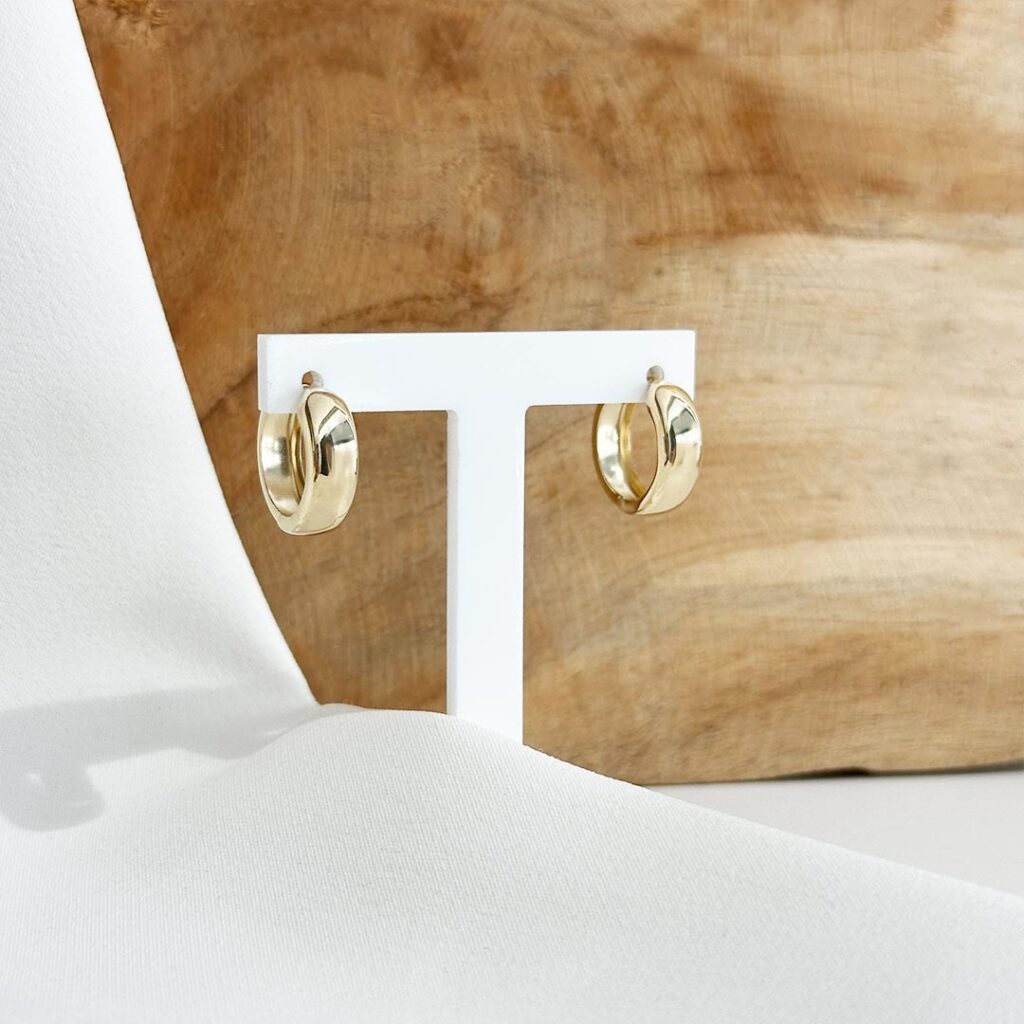 Creolen aus 585er Gelbgold mit 15mm Durchmesser und ca. 5mm Breite, polierter Oberfläche und klarer Form, in eleganter Nahaufnahme gezeigt.