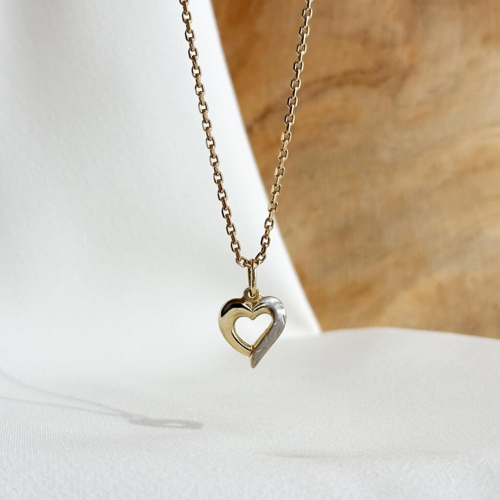 Herzanhänger aus 585 Weiß- und Gelbgold, 13mm groß, mit polierter Gelbgoldhälfte und matt strukturierter Weißgoldhälfte, in eleganter Nahaufnahme gezeigt.