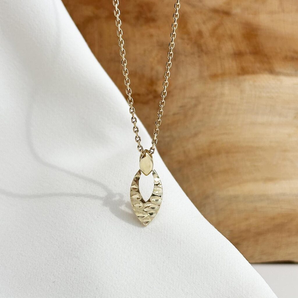 Navette-Anhänger aus 585 Gelbgold mit durchbrochener Mitte und stark strukturierter Oberfläche auf einer Goldkette, in eleganter Nahaufnahme präsentiert.