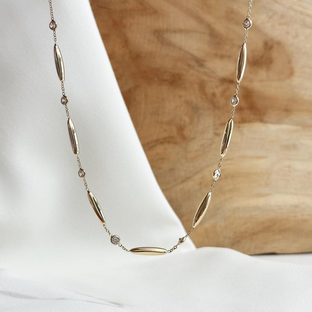 Goldkette aus 585er Gelbgold mit länglichen Zwischenelementen und kleinen farblosen Zirkonia, 45cm Länge mit Zwischenöse bei 42cm, in eleganter Nahaufnahme präsentiert.