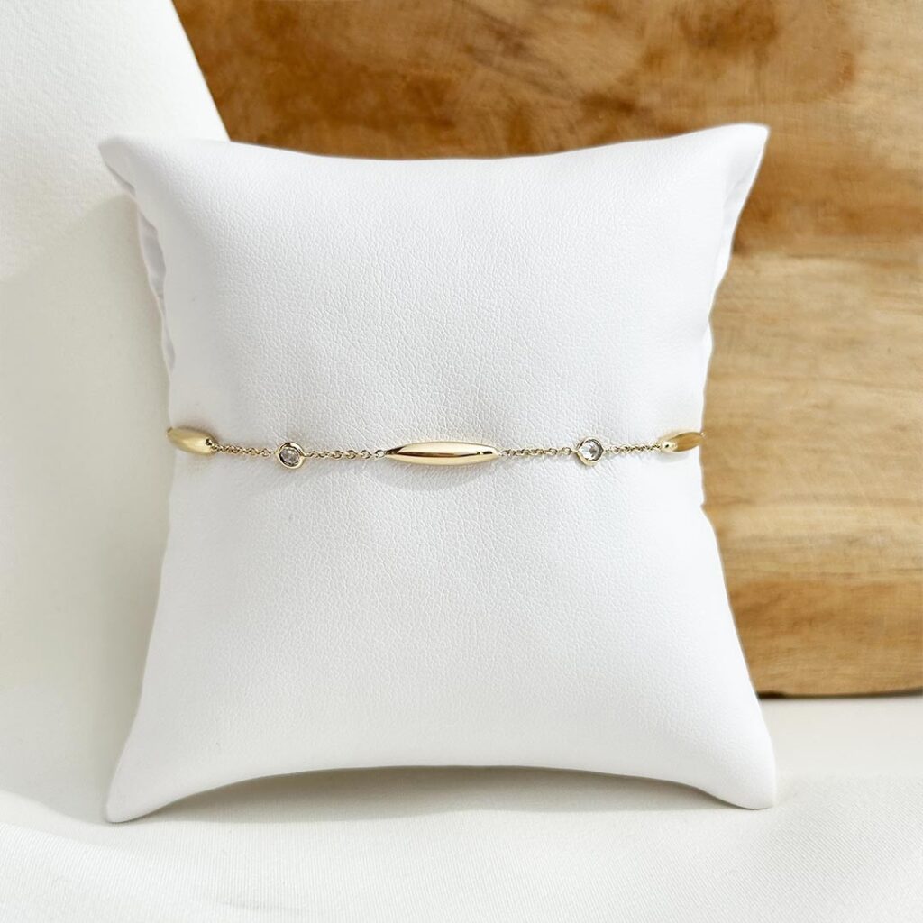 Zartes Armband aus 585er Gelbgold mit feinen länglichen Elementen und kleinen farblosen Zirkonia, 19cm Länge mit Zwischenöse bei 17cm, in eleganter Nahaufnahme gezeigt.