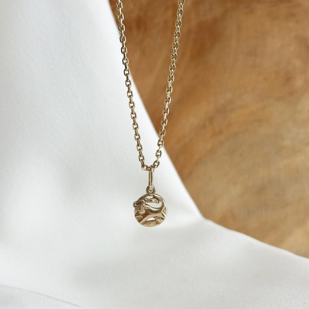 Runder Sternzeichenanhänger aus 585er Gelbgold mit zart gearbeitetem Stier-Motiv, 9mm groß auf einer Goldkette, in eleganter Nahaufnahme gezeigt.