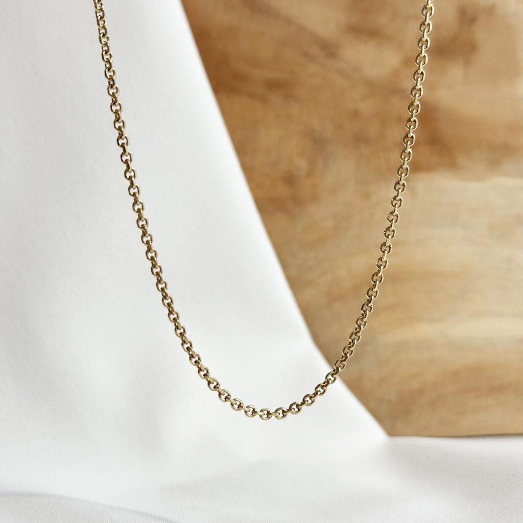Karreekette aus 585er Gelbgold, 45cm lang und 2mm stark, mit ovalen leicht facettierten Gliedern, in eleganter Nahaufnahme präsentiert.