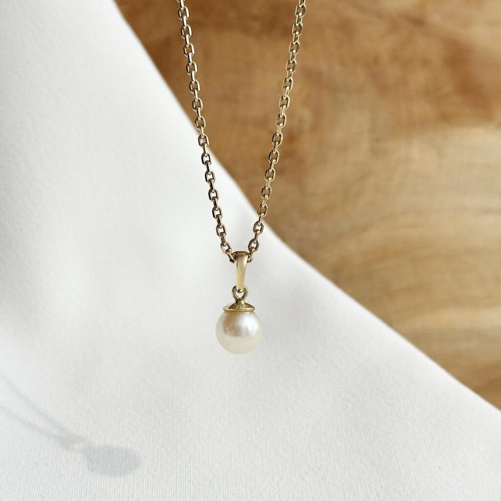 Schlichter Perlenanhänger aus 585er Gelbgold mit feiner Akoya-Perle auf einer Goldkette, in eleganter Nahaufnahme präsentiert.