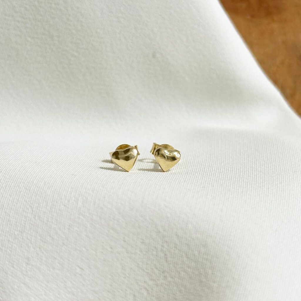 Kleine Herzohrstecker aus 585er Gelbgold, 4mm groß, mit polierter Oberfläche, in eleganter Nahaufnahme gezeigt.