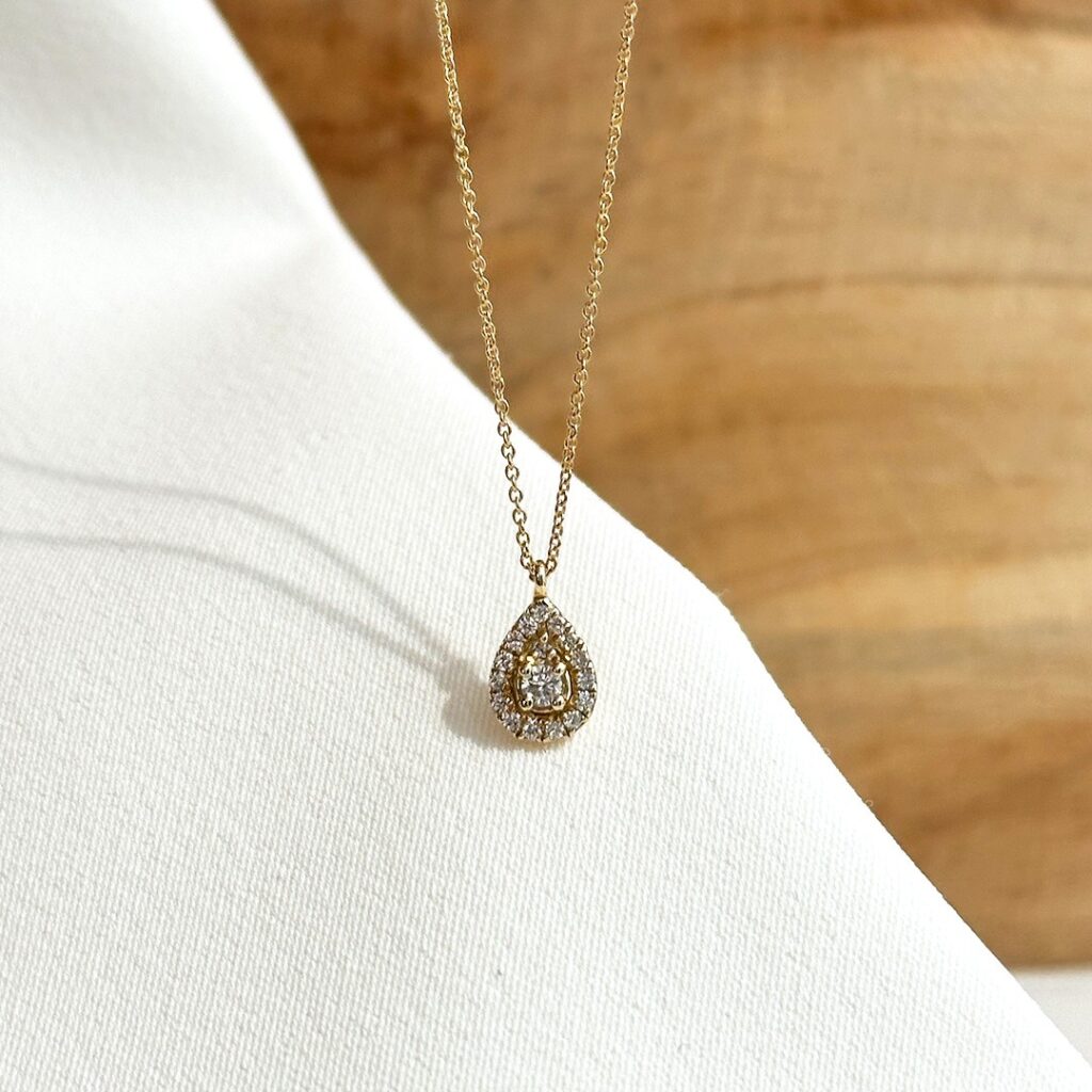Zartes Diamant-Collier aus 585er Gelbgold mit 10mm Tropfenanhänger, im Zentrum ein größerer Diamant, umgeben von kleineren funkelnden Steinen; an einer 45cm Goldkette mit Zwischenöse bei 42cm elegant in Nahaufnahme präsentiert.