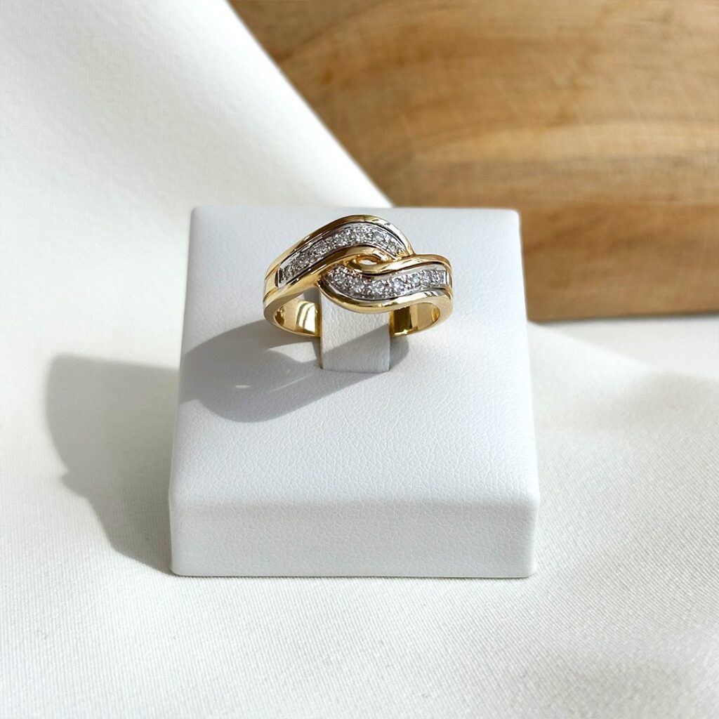 Ring aus 585er Gelb- und Weißgold mit harmonisch geschwungener Form und zwei Brillantreihen in fein gearbeiteten Weißgold-Elementen, in eleganter Frontansicht präsentiert.