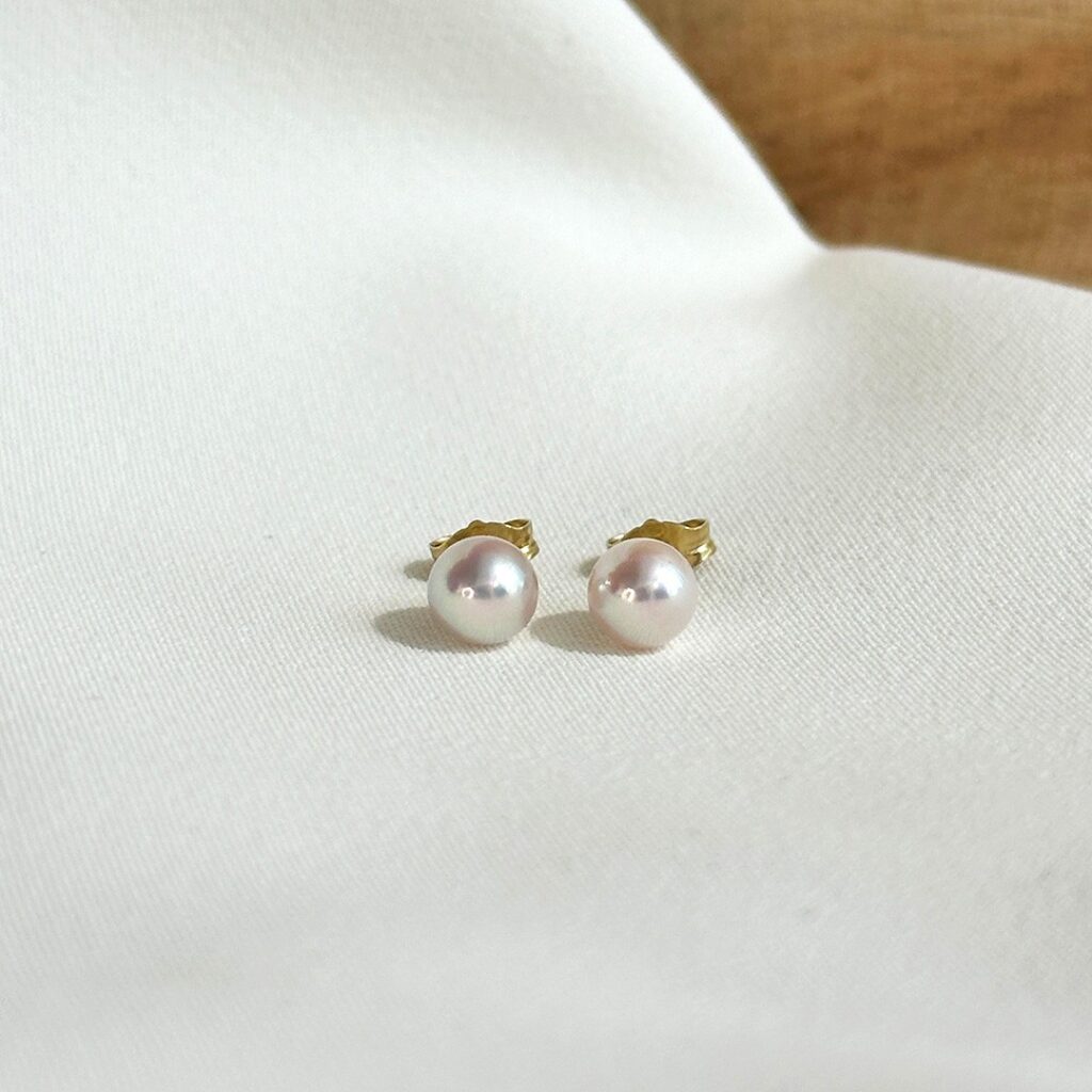 Ohrstecker aus 585er Gelbgold mit zarten Akoya-Perlen von ca. 5,5mm Durchmesser, in klarer Frontansicht elegant fotografiert.