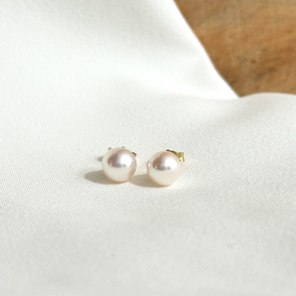 Ohrstecker aus 585er Gelbgold mit zarten Akoya-Perlen von ca. 6,5mm Durchmesser, in klarer Frontansicht elegant fotografiert.