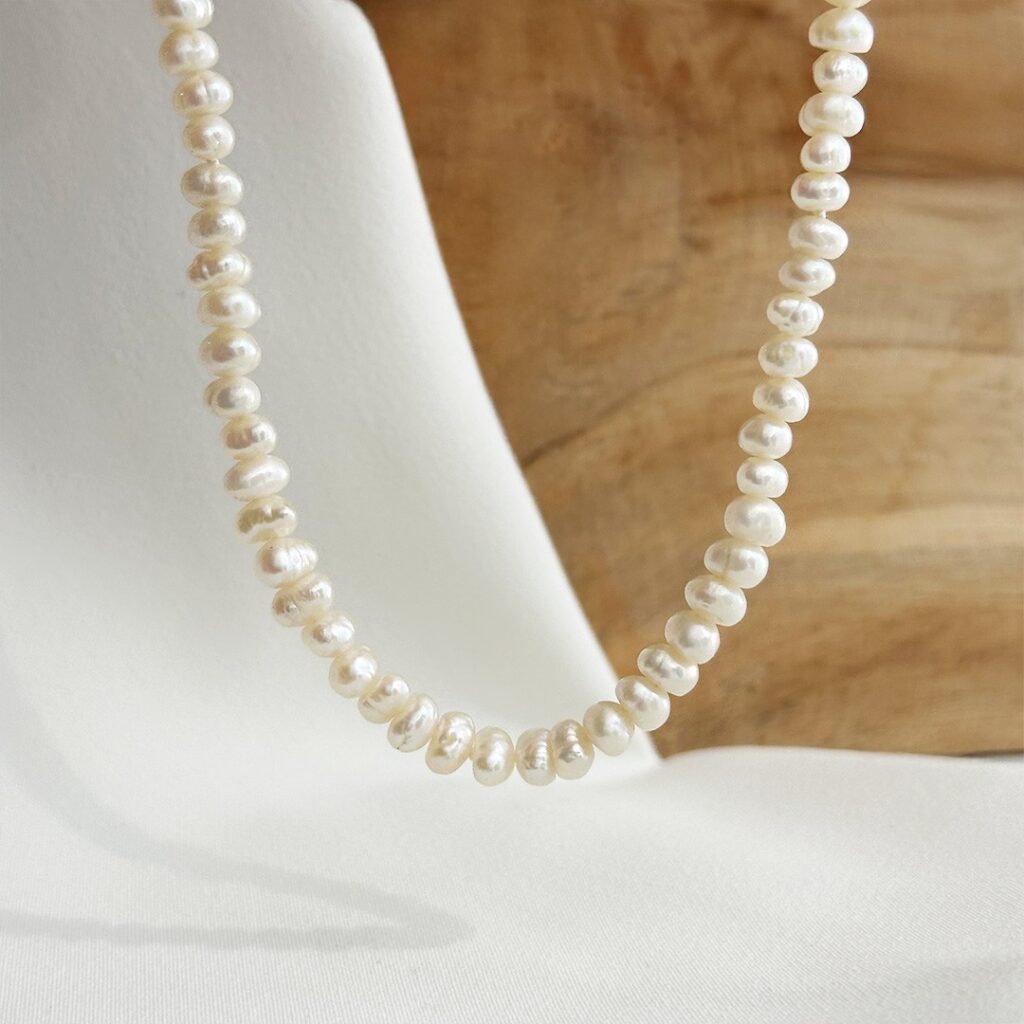 Perlenkette mit 4,5–5,5mm unregelmäßigen Süßwasserperlen, 44cm lang, elegant in Nahaufnahme präsentiert.