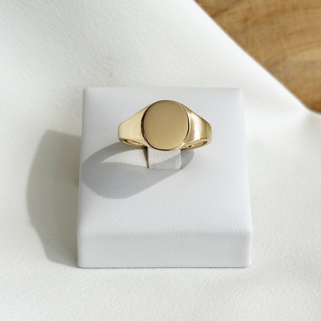 Gravurring aus 750 Gelbgold mit 11mm Gravurfläche und sanft ovaler Form, in klarer Frontansicht elegant fotografiert.