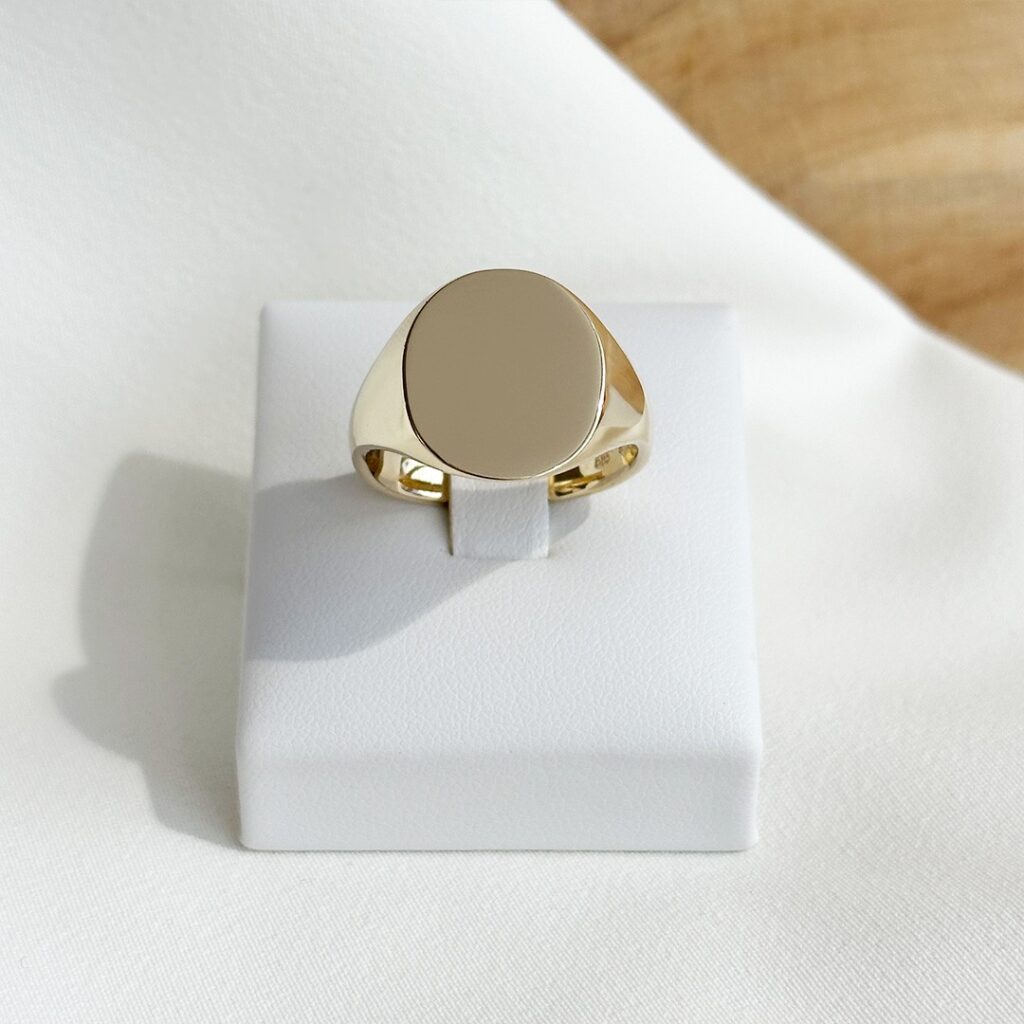 Klassischer Gravurring aus 585 Gelbgold mit leicht ovaler Gravurfläche von 16mm Durchmesser, in klarer Frontansicht elegant fotografiert.