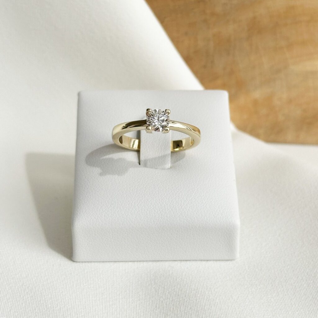 Solitär-Verlobungsring aus 585er Gelbgold mit 0,54ct. Brillant in 4-Krappen-Fassung, klassisch und elegant auf einem Ringpodest fotografiert.
