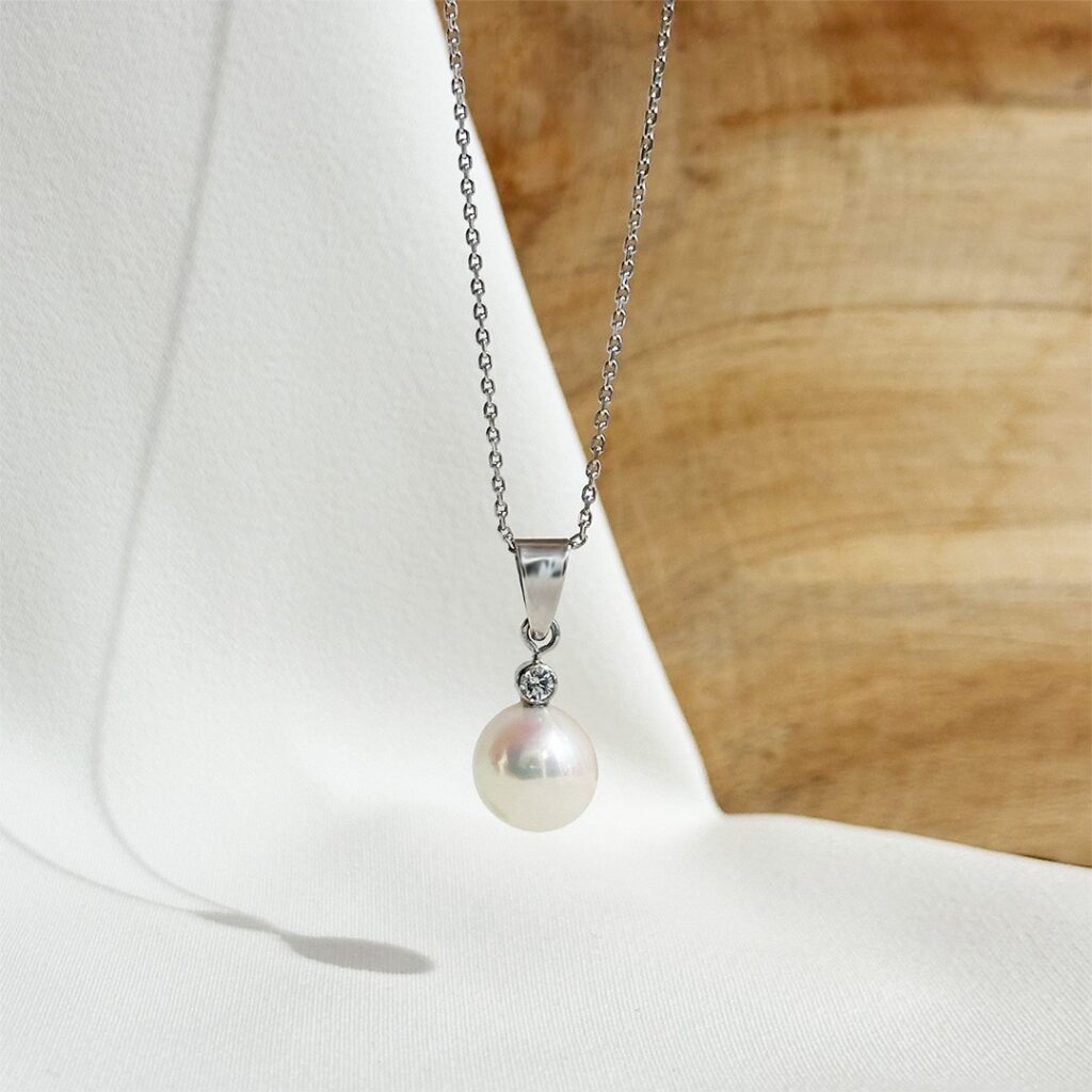 Perlenanhänger aus 585 Weißgold mit Akoya-Perle oberhalb einen rund gefassten 0,08ct Brillant, elegant an einer schlichten Weißgoldkette präsentiert.