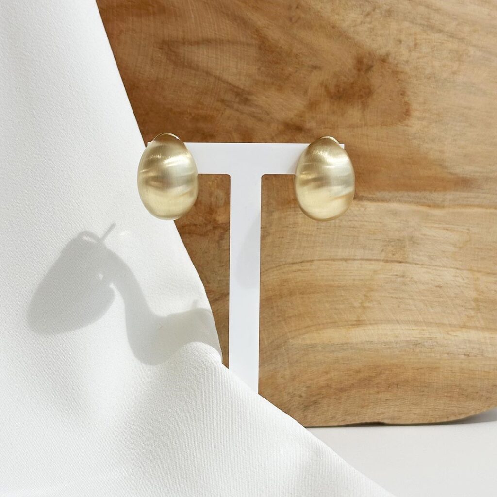 Ohrclips mit Dorn aus 585 Gelbgold, halbrund und mattiert, klar und elegant in frontalem Produktfoto präsentiert.