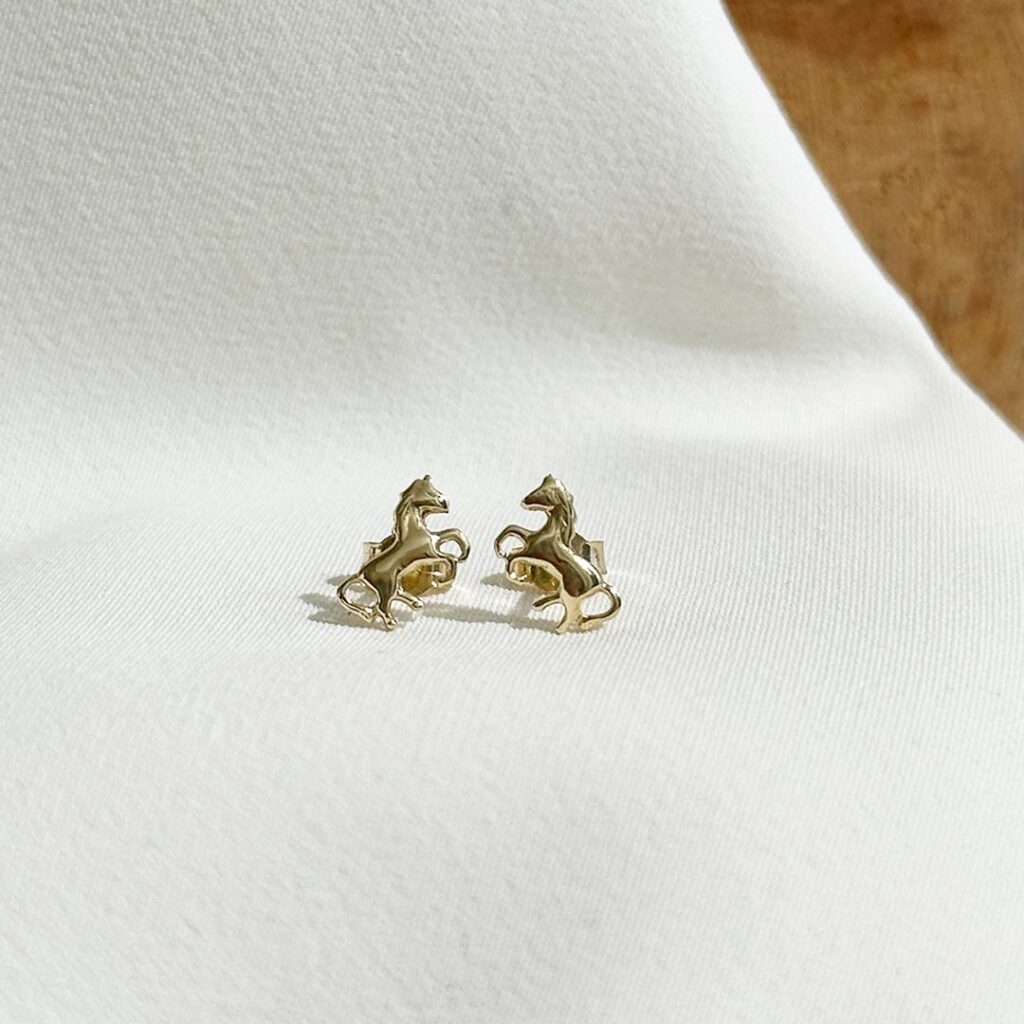 Pferde-Ohrstecker aus 585 Gelbgold in kindgerechter Gestaltung, frontal fotografiert; kleines galoppierendes Pferd mit 7mm Größe.