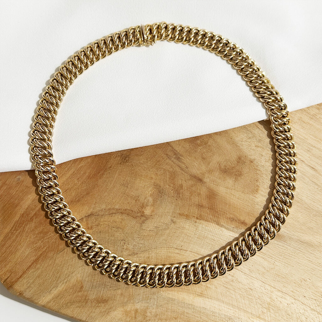 Doppelpanzerkette aus 585er Gelbgold, 45cm lang und 12mm breit, liegend auf elegantem Untergrund präsentiert, Fokus auf die dichte Gliederstruktur und den weichen Fall