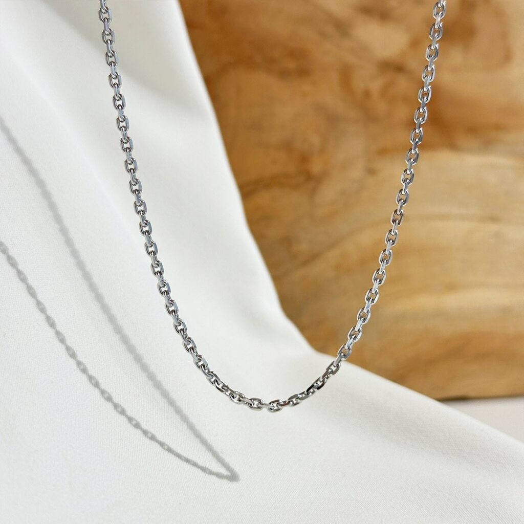 Goldkette für Anhänger aus 750 Weißgold: Karreekette mit einer Länge von 45cm und einer Stärke von 1,2mm - Nahaufnahme vor einer eleganten Rückwand