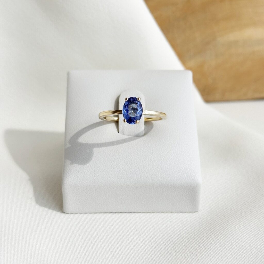 Tansanitring aus 585er Gelbgold, frontal auf Ringaufsteller in Nahaufnahme präsentiert, Betonung des ovalen Edelsteins, der klaren Fassung und der eleganten, leichten Gestaltung
